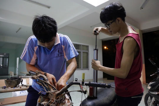 Đa số các dụng cụ sửa xe đều được các bạn chạy đi mượn khắp nơi hoặc tự chế dụng cụ thay thế. Trong ảnh: Do không có máy xịt hơi, các bạn phải mượn chiếc bơm tay để thổi khô các mạch điện