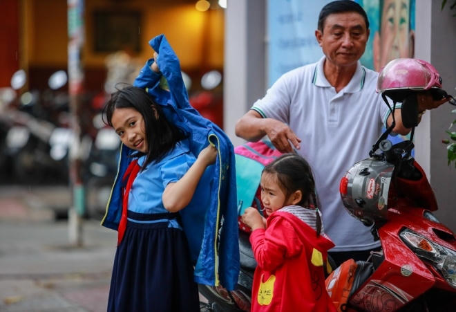 "Trời Sài Gòn bữa nay lạnh, nhiều gió hơn so với ngày thường nên tôi phải mang theo áo ấm cho hai cháu để chống nhiễm lạnh", ông Kỳ, ông nội của hai bé Khánh Linh và Khánh Phương (học sinh Trường tiểu học Đinh Tiên Hoàng, quận 1), nói.