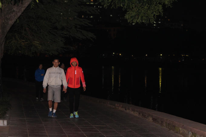 Nhiều người dân phải mặc áo ấm khi đi tập thể dục buổi tối tại công viên Nghĩa Đô.