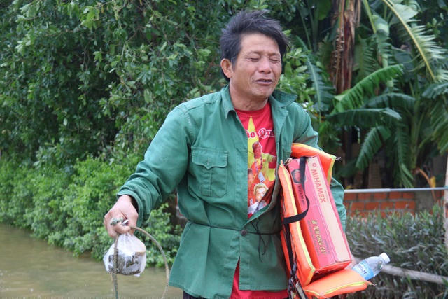 Ông Nguyễn Huy Nhung khóc khi bất lực nhìn con trâu bị cuốn trôi, trên tay ông vẫn còn cầm chiếc dây thừng buộc trâu.