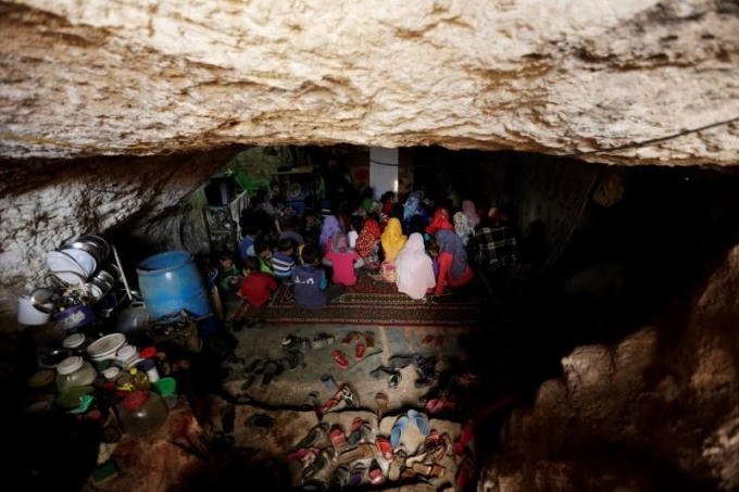 Ali cho biết "cháu học trong 1 cái hang, điều kiện không được tốt nhưng thầy giáo và vợ đối xử với chúng cháu rất tốt. Chúng cháu ngồi học dưới nền đất và thường không nhìn rõ vì bên trong rất tối". (Ảnh: Reuters)