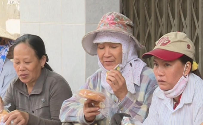 Người lao động ấm lòng bên những chiếc bánh mỳ từ thiện.