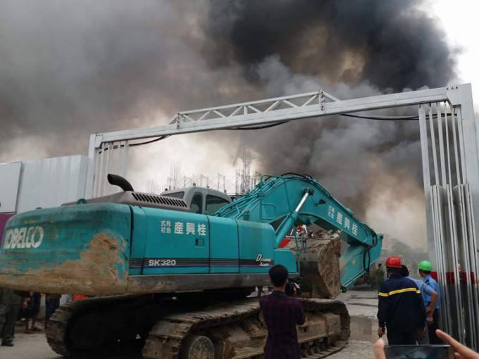 Máy xúc tiến vào hiện trường.