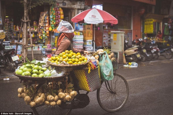 Chị bán hoa quả dùng cả túi nilon đội đầu khi trời đổ mưa lất phất.