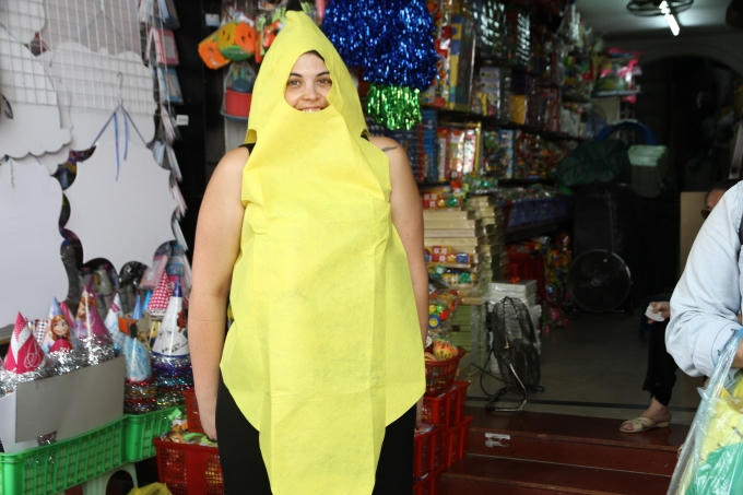 khách du lịch ướm thử vào người một bộ trang phục sặc sỡ