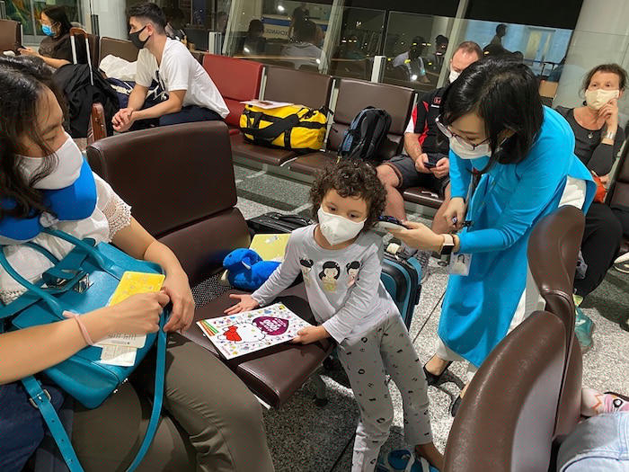 Nhân viên hãng hàng không đang kiểm tra thân nhiệt cho hành khách.