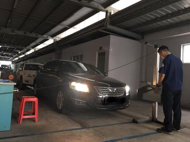 Nhân viên đăng kiểm đang kiểm định đèn xe. Ảnh: TN.