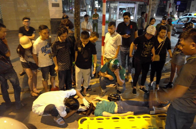 Cô gái bị thương ở phần đầu được đội ngũ cấp cứu kiểm tra ban đầu. Ảnh: Quyết Thắng