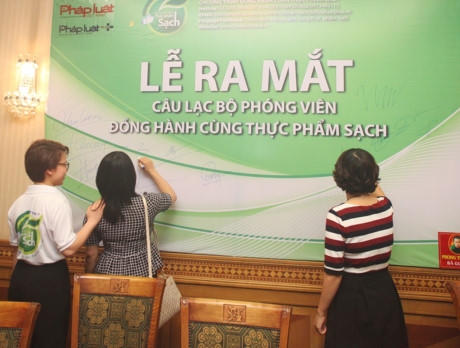 Các phóng viên, nhà báo cùng ký lưu bút Đồng hành cùng thực phẩm sạch. (Ảnh: Việt Cường)