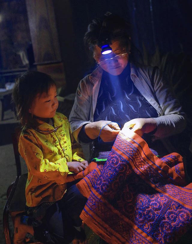 Mẹ ngồi xỏ chỉ luồn kim - Ảnh: Hoàng Đông