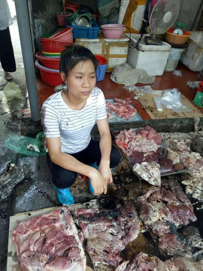 1 Hình ảnh chị Xuyên thất thần bên đống thịt lợn bị đổ chất thải. Ảnh: Facebook.