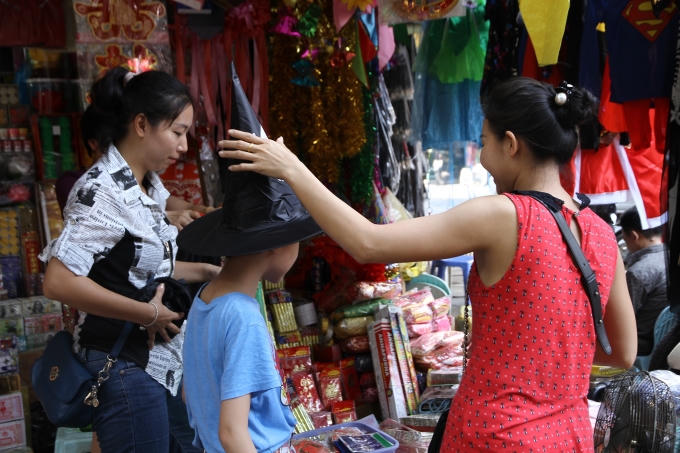 Hai mẹ con đưa nhau đi mua trang phục hóa trang.