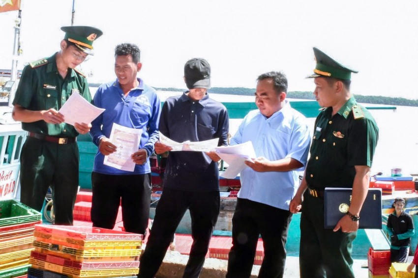 Cán bộ Đồn Biên phòng Trung Bình cấp phát tờ rơi tuyên truyền bầu cử tới các chủ phương tiện tàu thuyền