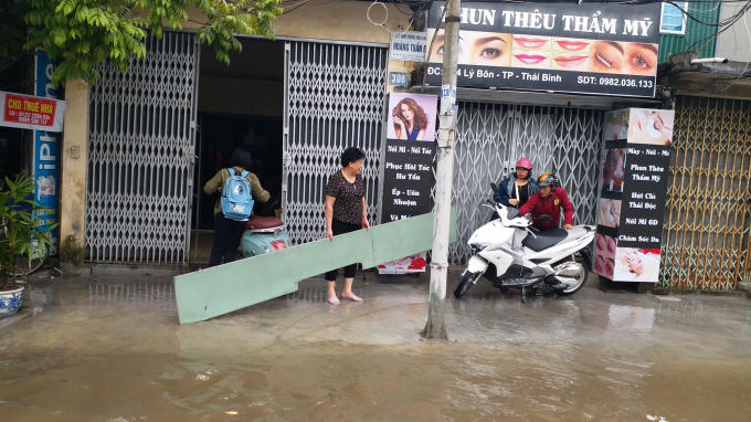 Nhiều nhà sắm những tấm tôn kiên cố để chắn nước tràn vào nhà.
