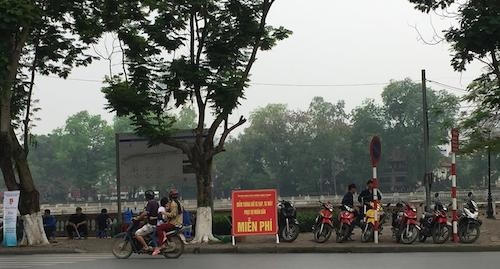 Biển thông báo trông giữ xe miễn phí cho du khách vào tham quan công viên Thủ Lệ.