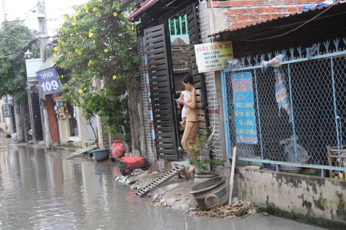 Nước ngập thế này thì chỉ có thể đứng trong nhà nhìn ra đường.