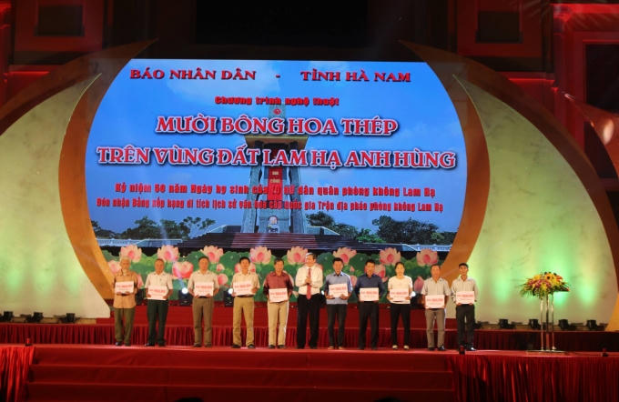 Đồng chí Đinh Thế Huynh đã trao sổ tiết kiệm cho thân nhân 10 nữ liệt sĩ dân quân phòng không xã Lam Hạ.