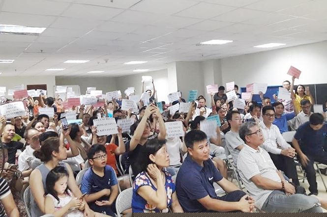 Người dân KĐT Đại Thanh họp với các bên liên quan và giơ bảng ý kiến phản đối việc thay đơn vị cấp nước sạch.