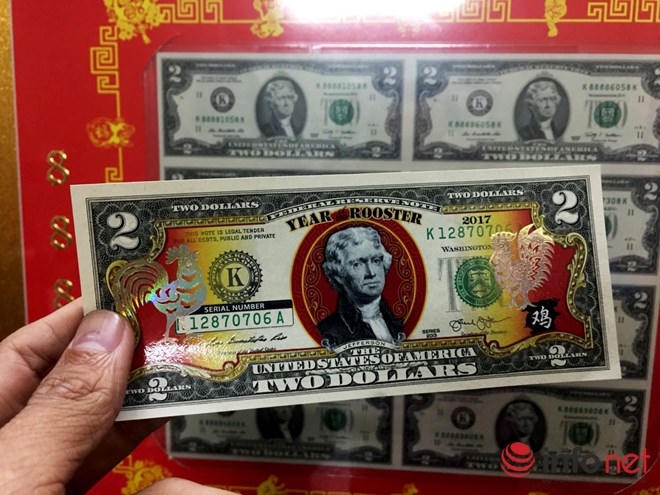 Tờ tiền mệnh giá 2 USD này là tiền thật được phun màu, chế tác hình con gà bán với giá 400 ngàn đồng. Loại tiền tương tự có mệnh giá 1 USD bán giá 350 ngàn/tờ. Chủ điểm bán cho biết loại 1 USD chưa nhập về kịp do qua tết dương lịch 2017 phía Mỹ mới sản xuất.