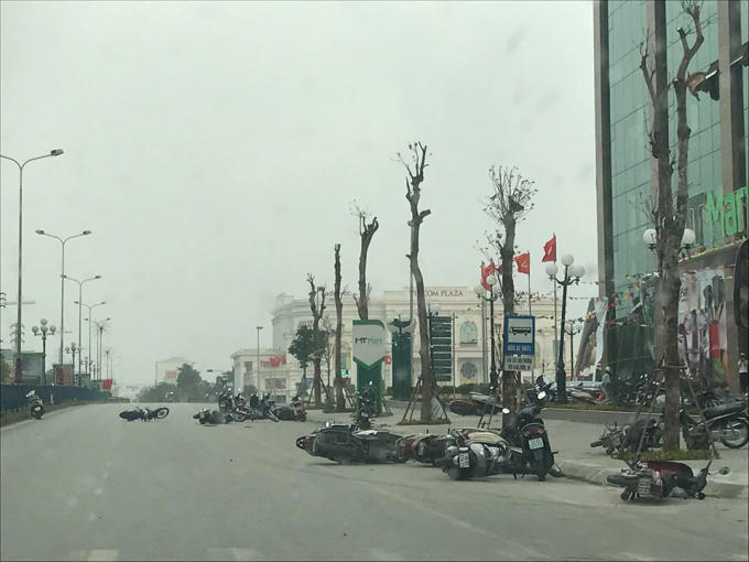 Hình ảnh nhiều xe máy bị đổ ra đường khi cơn giông ập đến. Ảnh N.D.
