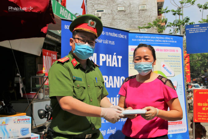 Người dân nhận khẩu trang ở điểm phát trước cổng vào chợ Cống Vị.