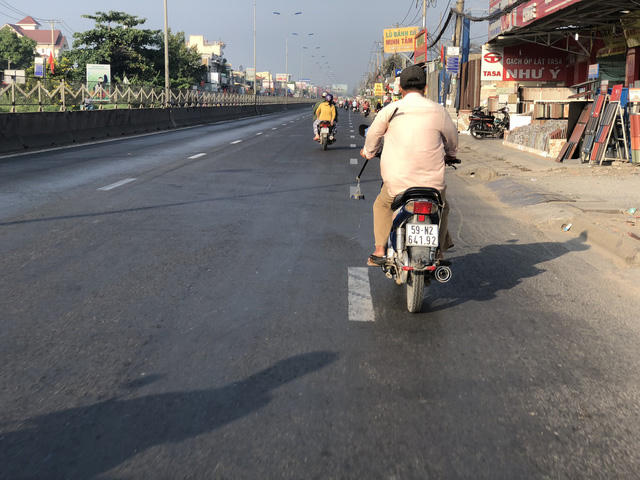 Ông C. vừa chạy xe máy vừa thu nhặt những cây đinh do kẻ xấu thả xuống đường