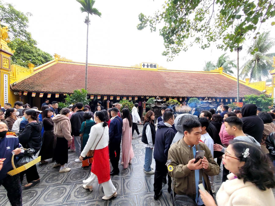 Ở ngoài sân nghi ngút khói hương, rất đông người tới thăm quan và bái lễ. (Ảnh: Phạm Duy)