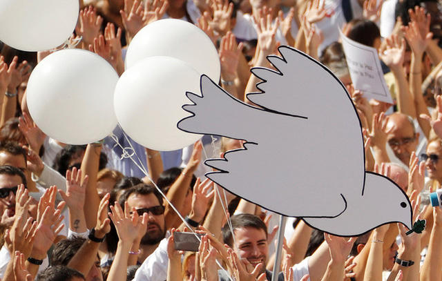 Đám đông biểu tình hô vang khẩu hiệu “Chúng tôi muốn đàm phán”, và giơ cao các biểu tượng thể hiện hòa bình như chim bồ cầu trắng, bóng bay. (Ảnh: RT)