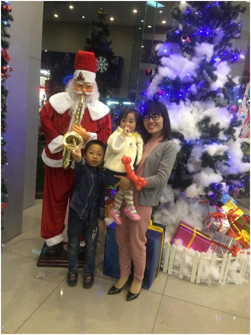 Gia đình chị Len vui vẻ chụp hình kỉ niệm bên cây thông và ông già Noel.
