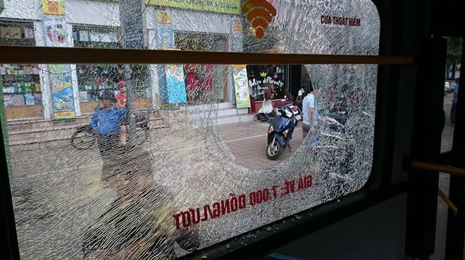 Cô gái không nghe lời và bước lên xe. Nam thanh niên ném thẳng viên gạch vào cửa kính xe buýt. Ảnh: H.A / An ninh thủ đô.