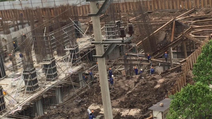 Những công nhân này đang thu dọn cốt pha, sắt thép để bảo quản theo trả lời của ông Tuyên. (Ảnh Thanh Thắng)