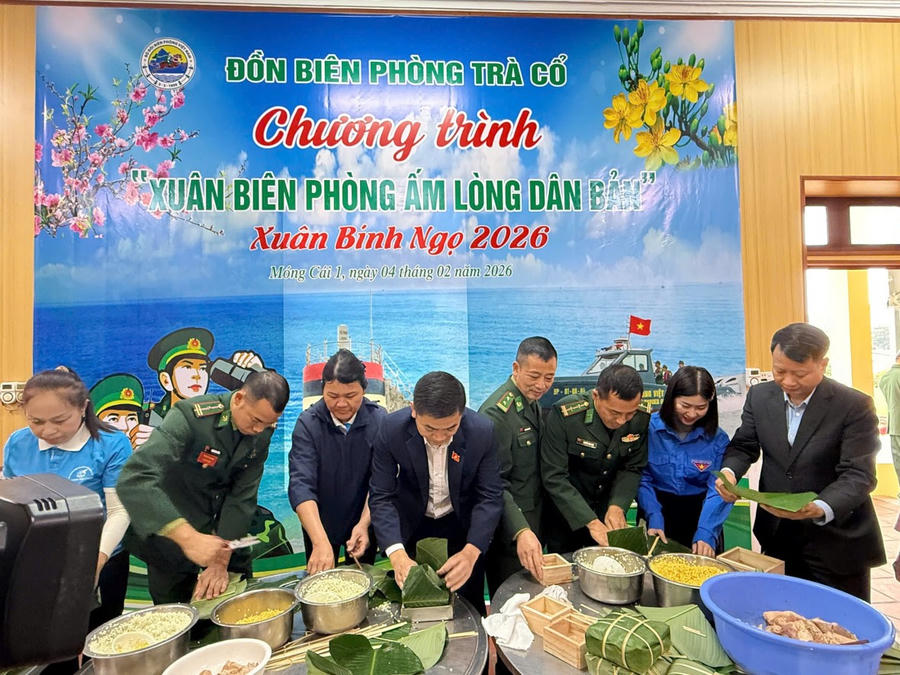 Cán bộ, chiến sĩ Đồn Biên phòng Trà Cổ cùng đại biểu gói bánh chưng tại chương trình “Xuân Biên phòng ấm lòng dân bản”.