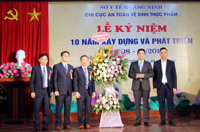 PGS. TS Nguyễn Thanh Phong, Cục trưởng Cục An toàn thực phẩm (thứ hai từ phải sang) dự và tặng hoa chúc mừng Chi cục An toàn vệ sinh thực phẩm tỉnh Quảng Ninh.