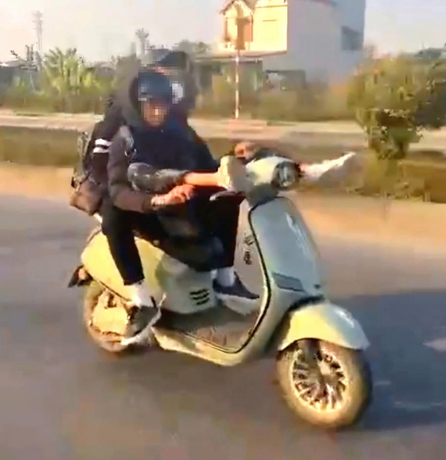 Hình ảnh 2 thiếu niên lái xe bằng chân.