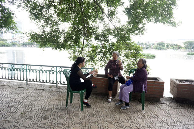 Người cao tuổi trò chuyện bên hồ Trúc Bạch, hít hà không khí lạnh ngọt cuối thu.