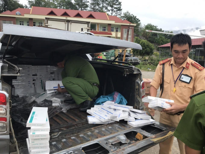 Lực lượng chức năng đang kiểm đếm số thuốc lá lậu trên xe ô tô.