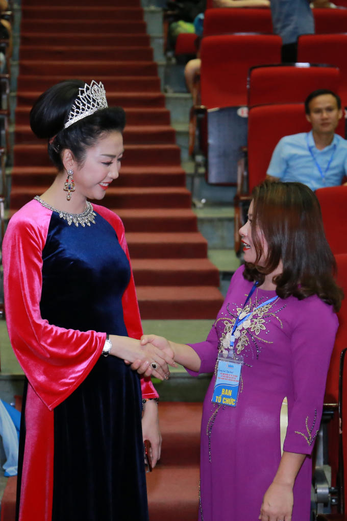 Tân hoa hậu Võ Nhật Phượng xuất hiện xinh đẹp, dịu dàng với trang phục áo dài nhung màu xanh đen, điểm xuyến màu hồng.