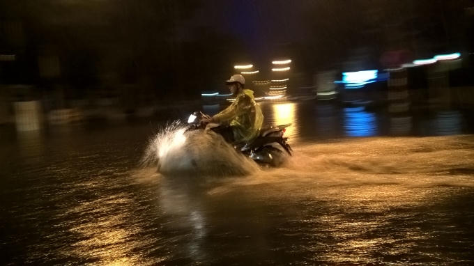 Người điều khiển xe gắn máy cố gắng đi nhanh qua các đoạn đường bị ngập.