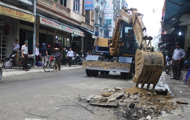 Máy múc được huy động san lấp những tuyến phố có công trình xây trái phép lấn vỉa hè. (Ảnh: A.T)