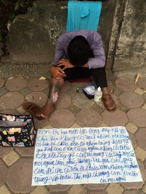 Nam thanh niên với tấm biển cầu xin sự giúp đỡ của mọi người.