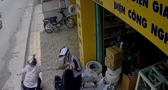 Tên cướp nhanh chóng vọt tới giật chiếc ví khi người phụ nữ đang chuẩn bị cất vào cốp.