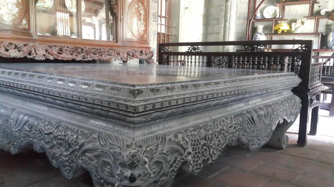 Trước kia, ngay gian chính của ngôi nhà được đặt chiếc sập bằng đá, trải qua thời gian dài chiếc sập cổ này bị gãy nên gia chủ thay bằng chiếc sập đá nguyên khối, được trạm khắc cầu kỳ hơn