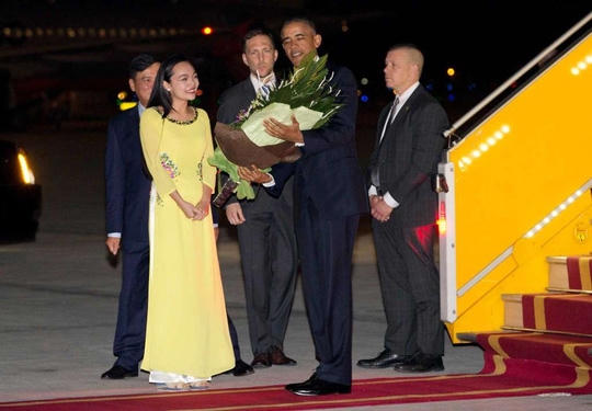 Tổng thống Mỹ Barack Obama được tặng hoa ngay khi đặt chân xuống sân bay Nội Bài. (Ảnh: AP)