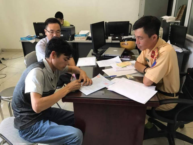 Lực lượng chức năng lập biên bản xử phạt đối với tài xế lái xe taxi đi vào đường ưu tiên.