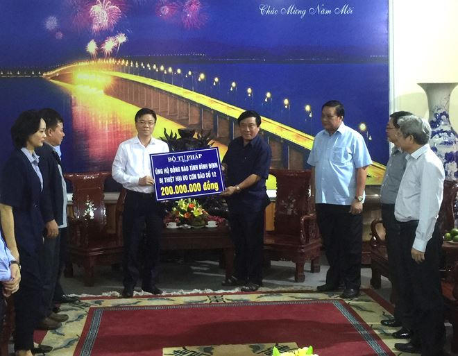 Bộ trưởng Lê Thành Long trao 200 triệu đồng, số tiền mà cán bộ, công chức Bộ Tư pháp ủng hộ nhân dân vùng lũ tỉnh Bình Định.