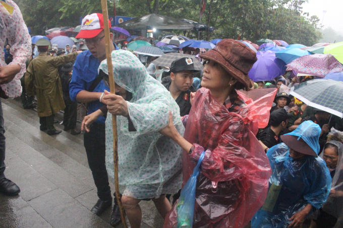 Một cụ già được người thân đưa lên vào đền thắp hương.