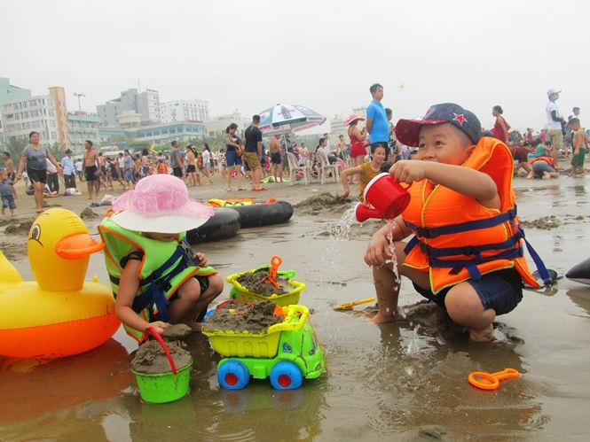 Nhằm đảm bảo an toàn cho du khách, lực lượng cứu hộ, cứu nạn đã phải đưa các ghế quan sát ra biển (cách mép nước khoảng 5 m) để đứng quan sát và liên tục nhắc nhở, dùng còi cảnh báo du khách không được bơi ra xa bờ khi tắm biển. Trong ảnh: Trẻ em vui chơi an toàn trên các bãi biển Sầm Sơn.