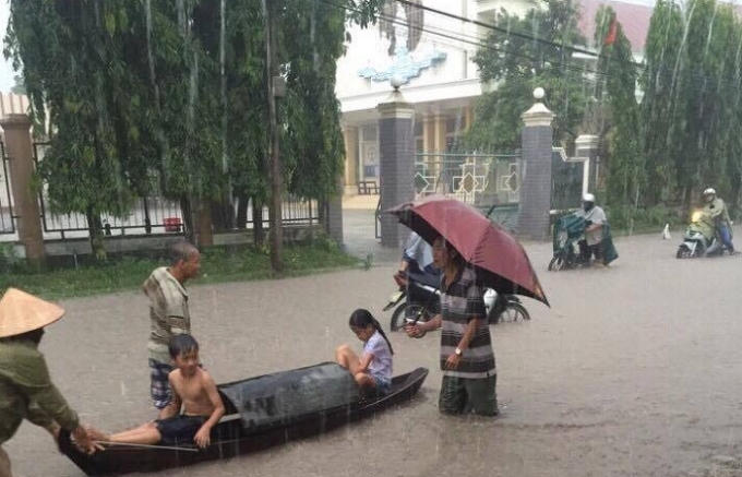 Nhiều người đi xe máy phải dắt bộ qua vùng nước ngập lụt. (Ảnh người dân cung cấp)