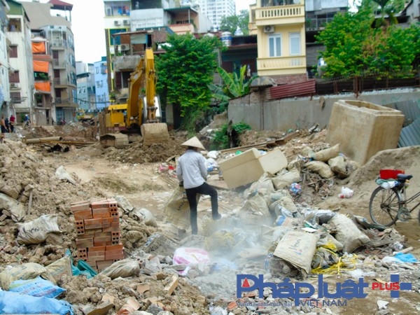 Mặt đường thành bãi rác, trong hình một người thu lượn sắt vụn đang nhặt nhạnh những gì còn sót lại.