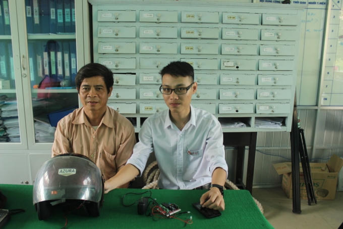 Khoa cùng thầy hướng dẫn bên cạnh chiếc mũ thông minh với nhiều vi mạch, cảm biến phức tạp